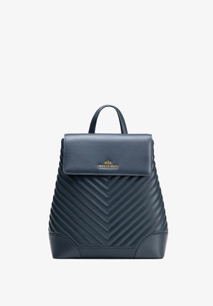 Zaino in pelle trapuntata blu navy con manico superiore e chiusura a patta con logo Wittchen dorato sul davanti.