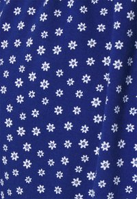 Tecido azul marinho com um padrão repetido de pequenas flores brancas com centros circulares. Textura suave com um fio uniforme.