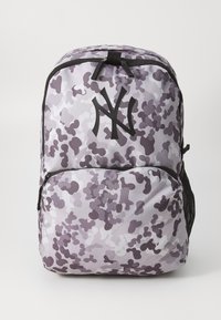 Zaino con motivo camouflage viola, dotato di un logo nero prominente, cerniere in tessuto e tasche laterali in rete. Design durevole e leggero.