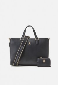 Black synthetic tote bag with gold hardware, featuring a detachable strap with "TOMMY HILFIGER" text and a matching small wallet.