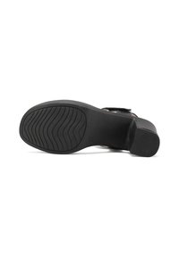 Sandal nero con una suola liscia, dotata di un fondo in gomma texturizzata, leggero tacco e una fascia sul piede per una calzata sicura.