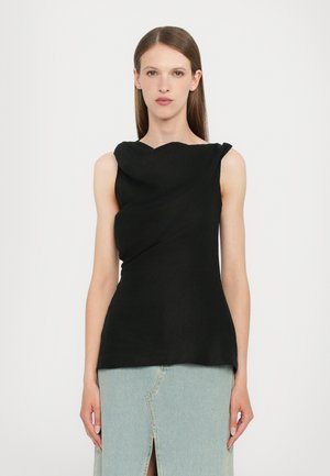 Black sleeveless top with a draped design and curved neckline, made from lightweight fabric. Paired with a light denim skirt featuring a slit.