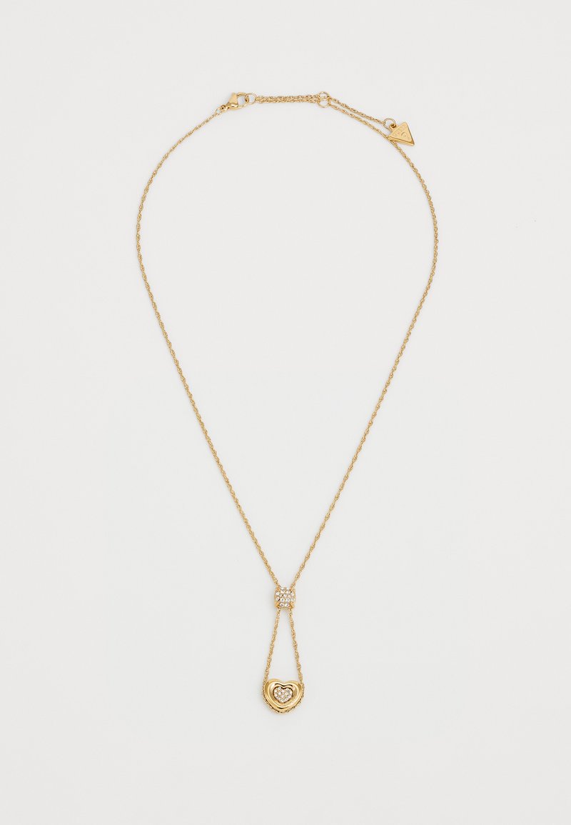 Gouden ketting met een gedraaid schakelsysteem, met een hartvormige hanger versierd met een textuur aan de rand en een kleine versiering erboven.