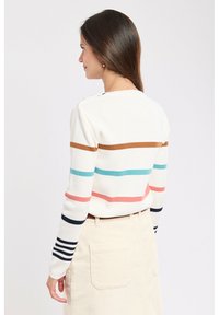 Pull rayé en blanc, présentant des bandes horizontales de marron, rose, bleu et marine ; encolure ronde ; poignets côtelés ; texture douce.