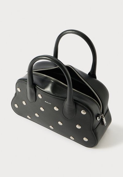 Black leather handbag with silver metal studs, rounded shape, dual handles, and a zip closure. Features a visible brand logo on the front.