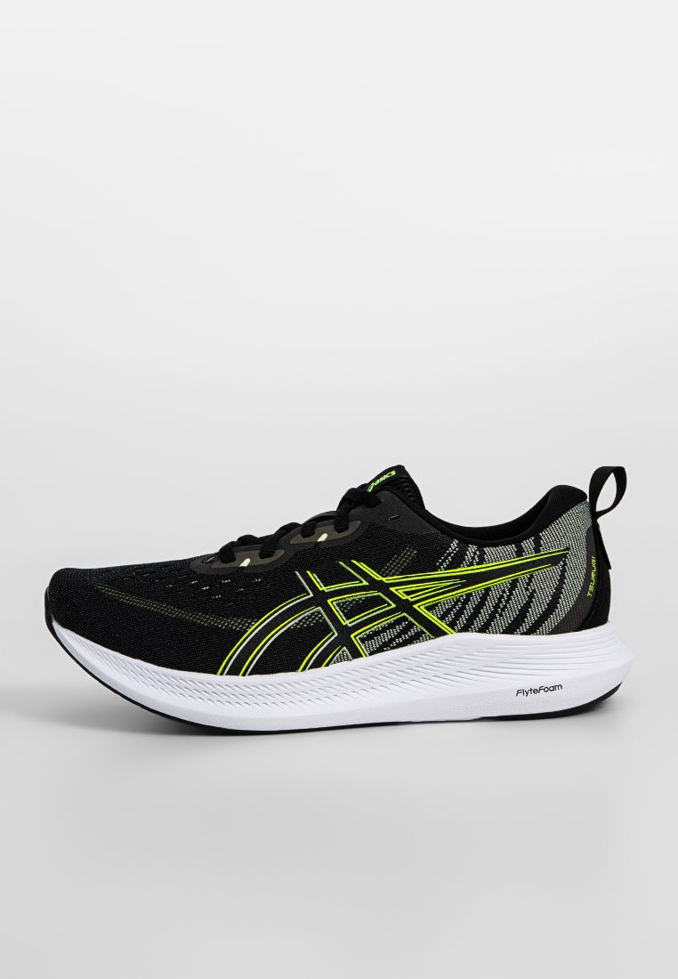 Zapatilla deportiva negra con acentos verdes, parte superior de malla y diseño texturizado. Presenta una mediasuela blanca etiquetada como "FlyteFoam". Perfil bajo con cierre de cordones.