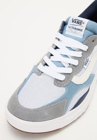 Sapatilha VANS Ultracange em azul claro, cinza e branco. Apresenta materiais em malha e camurça, atacadores brancos planos e uma sola de borracha texturizada.