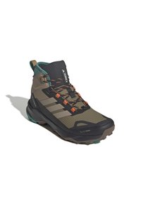 Hiking boot with a high ankle, dark green and brown textile, rubber sole, orange laces, and a geometric pattern on the upper.