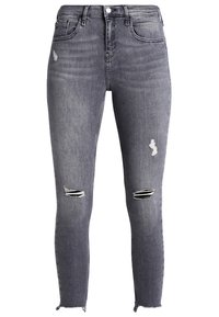 Jean ajustado en denim gris oscuro con detalles desgastados. Presenta dos desgarros en las rodillas, un dobladillo deshilachado y un diseño clásico de cinco bolsillos.