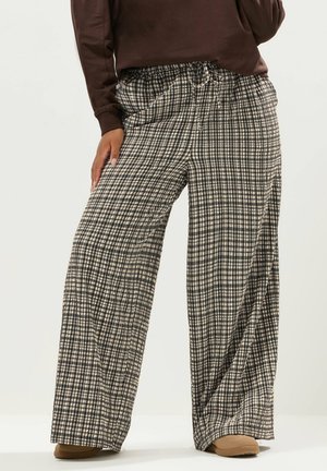 Pantalons à jambes larges avec un motif à carreaux noir et beige, fabriqués en tissu léger avec une taille élastique et un cordon de serrage.