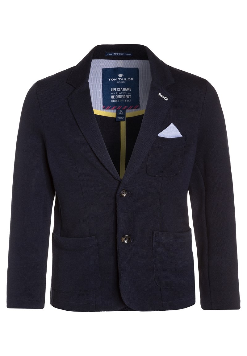 Námořnický blejzr vyrobený z texturované tkaniny, který má klopový límec, dvě přední kapsy a bílý kapesníček. Knoflíky jsou tmavé, kulaté.