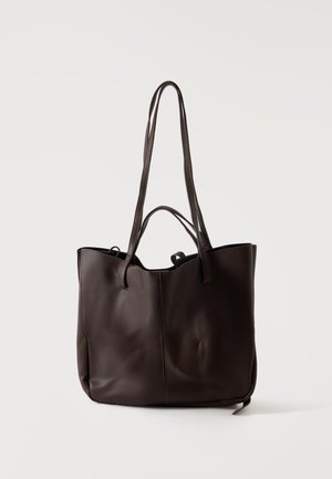 Sac cabas en cuir brun foncé avec deux longues bandoulières et deux poignées plus courtes, présenté sur un fond clair uni.
