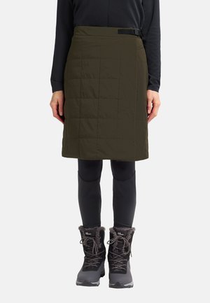 Olive green quilted skirt with a smooth texture and black belt detail, paired with black thermal leggings and fur-lined snow boots.