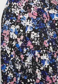 Blusa floral multicolorida em preto, azul, rosa e branco. Apresenta um tecido suave, design fluido e um padrão exclusivo de aquarela.