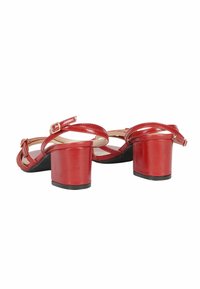 Sandali con tacco a blocco in pelle patinata rossa, con cinturini alla caviglia regolabili, design aperto e suola testurizzata per una maggiore aderenza.