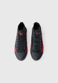 Zwarte en rode hoge sneakers van canvas met gefranjerde randen, zwarte veters en een rubberen zool. Logo weergegeven op de tong.
