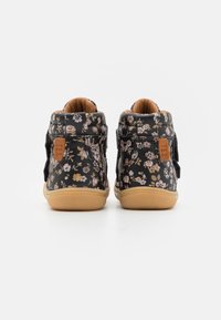 Černé květinové vysoké tenisky s texturovaným vzorem, béžovým interiérem a suchým zipem na uzavření; mají pevnou gumovou podrážku.