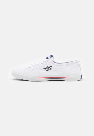 Baskets basses en toile blanche avec lacets blancs, bandes bleues et rouges sur la semelle et logo noir « Pepe Jeans London » sur le côté.