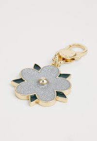 Porte-clé en or avec une fleur, un centre argenté pailleté et des accents de feuilles vert foncé. Dispose d'un mousqueton pour l'attache.