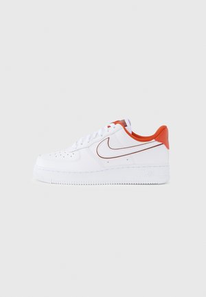 Valget nahast toss oranžide detailidega, tekstureeritud kummist tallaga, varbaplaadil perforatsioonidetail ja klassikaline Nike Swooshi logo punases värvitoonis.