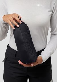 Zwarte, met rits gesloten tas vastgehouden in twee handen; gladde stof met een lichte glans; compact, rond van vorm; bevat een ophanglus voor draagbaarheid.