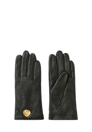 Par de guantes de cuero negro con un detalle decorativo circular dorado en la muñeca del guante izquierdo, mostrado plano con las palmas hacia abajo.