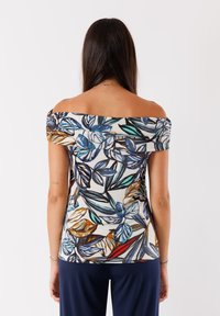 Top off-shoulder con stampa di foglie colorate in blu, verde e marrone su uno sfondo chiaro; tessuto morbido; design aderente.
