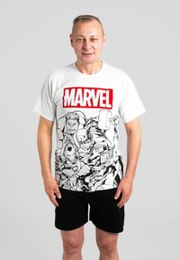 T-shirt in cotone grigio con logo rosso "MARVEL" e personaggi in stile fumetto neri stampati sul davanti. Abbinato a pantaloni corti neri.