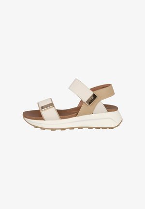 Sandalia casual beige y blanca con dos correas ajustables, plantilla acolchada marrón y suela blanca gruesa con dibujo para mejor agarre.