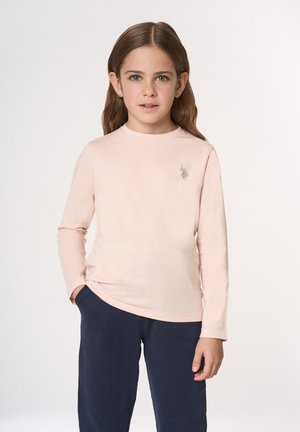 Camicia a maniche lunghe rosa chiaro con scollo rotondo e piccolo dettaglio logo sul petto, abbinata a pantaloni blu scuro. Tessuto dalla texture liscia.