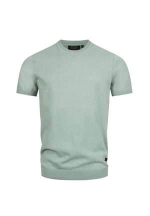 Maglione a maniche corte verde chiaro in maglia con collo a coste, polsini e orlo, con una piccola etichetta nera del marchio vicino all'orlo inferiore.