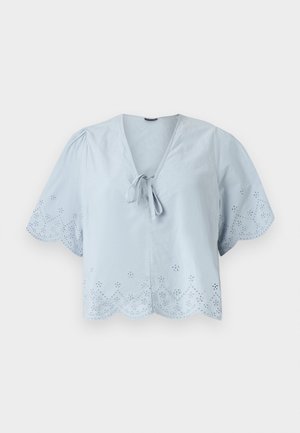 Ljust blåcroppad blus med korta puffärmar, dekorativa hålmönster längs fållen och en knytdetalj vid V-ringningen.