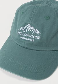 Zöld pamut baseballsapka hímzett hegy mintával és fehér "YELLOWSTONE National Park" felirattal. Görbült karimával rendelkezik.