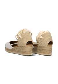 Wedge espadrilles met een witte leren voorkant en een beige geweven achterkant, met gevlochten accenten en een textuur touw platformzool.