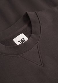 Dark gray sweatshirt featuring a round neckline, ribbed cuffs, and a V stitch on the front. Soft texture with a woven label inside.