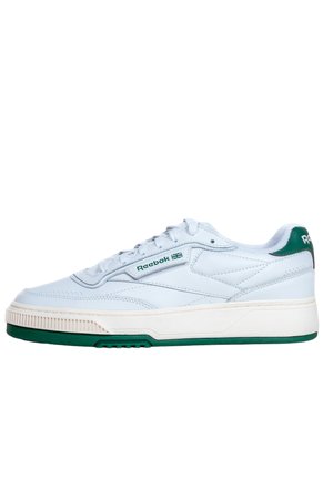 Sneaker basso bianco Reebok con dettagli verdi, lacci e logo marchiato sul lato e sul tallone, con suola spessa bianca e verde.