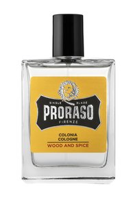 Klar glas cologne flaske med en sort kapsel og en gul etiket. Etietten har et løve-logo og teksten "PRORASO COLONIA WOOD AND SPICE."