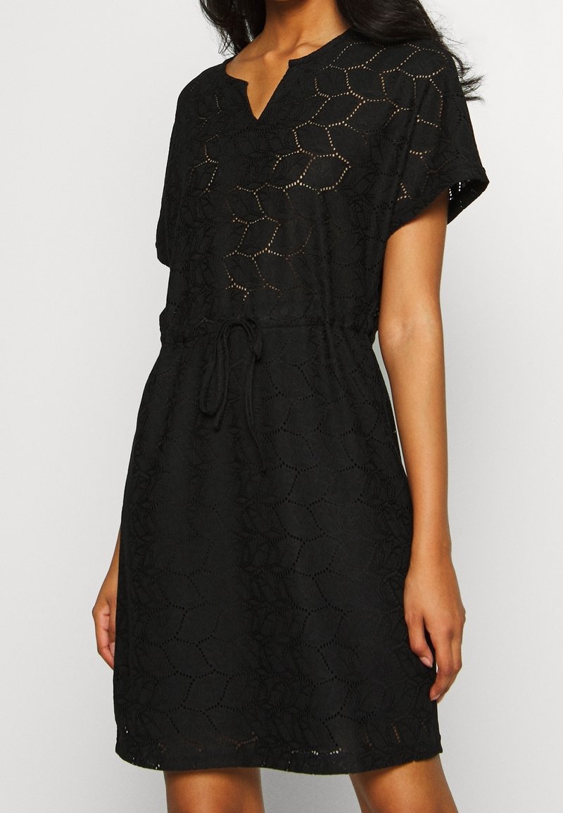 Robe noire à coupe ample, manches courtes et encolure en trou de serrure. Présente un motif texturé et un cordon ajustable à la taille.