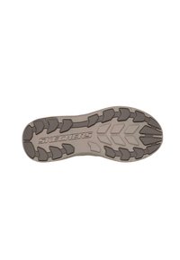 Suela de goma gris con patrones de textura y la marca "SKECHERS". Presenta diversas formas para tracción y soporte.