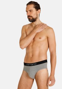 Slip di cotone grigi con una fascia nera che presenta il nome del marchio "camano" in lettere bianche. Texture morbida e design aderente.