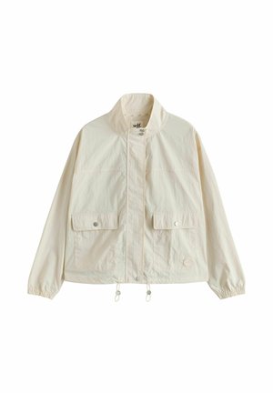 Lekka jasnobeżowa kurtka z wysokim kołnierzem, z przodu zapięcie na napy, dwie kieszenie z patkami, elastyczne mankiety i regulowane sznurki w dolnym obszyciu.