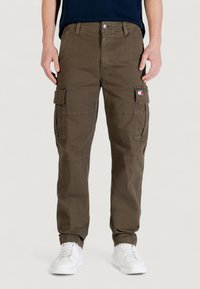 Pantalon cargo en mélange de coton vert olive, avec poches latérales, coupe classique et petite étiquette logo sur la jambe droite.