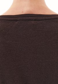 Bruine geribde top met een ruime halslijn, met een zachte textuur en een aansluitend ontwerp. Duidelijke naden bij de halslijn en schouders.
