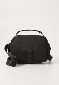 Black rectangular bag made from textured fabric, featuring a top handle, adjustable shoulder strap, front buckle closure, and a minimalistic design.