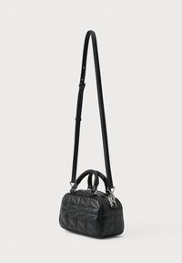 Maza melna kvadrāta ādas rokassomiņa ar divām īsām rokturām un regulējamu garu plecu jostu, kas karājas vertikāli.