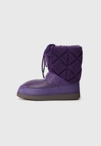Botín púrpura con base de goma y parte superior de forro polar acolchado. Presenta una textura con patrón, cordones ajustables y una banda grabada con "NO LOVE".