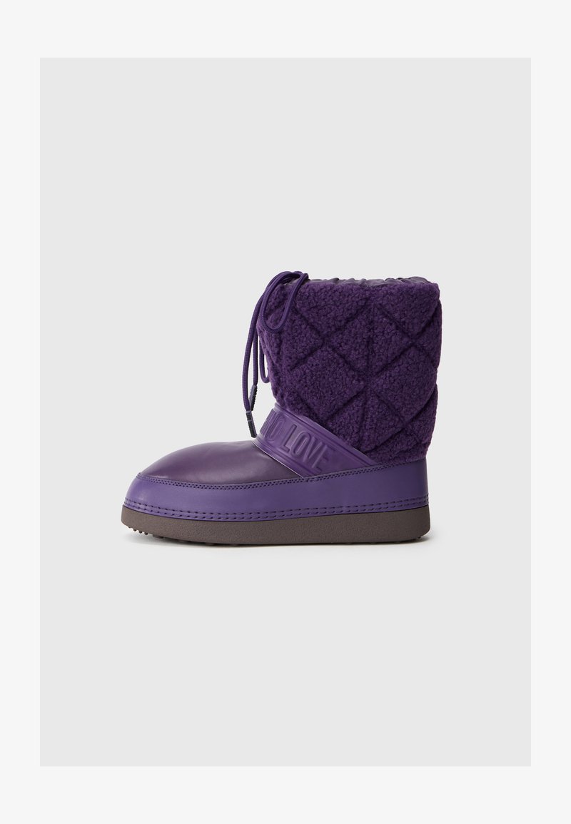 Fioletowy but z gumową podeszwą i pikowanym futerkiem. Posiada wzorzystą teksturę, regulowane sznurowanie oraz wytłoczoną taśmę z napisem "BEZ MIŁOŚCI".