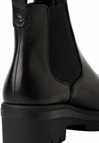 Stivale Chelsea in pelle nera con pannelli elasticizzati, texture liscia, punta arrotondata e suola in gomma spessa con scanalature per la trazione.