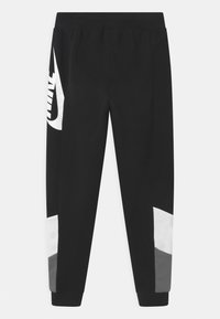 Svarta joggers från Nike med vitt logotyp, kontrasterande gråa och vita paneler, elastisk midja och smalnande muddar. Slät tygfinish.
