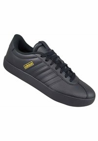 Czarne skórzane trampki o teksturowanej powierzchni, z trzema poziomymi paskami, okrągłym noskiem i czarnymi sznurówkami. Złote logo "adidas" z boku.